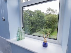 A window with bottles and a view of trees at Whinstone Cottage Esk Valley near Grosmont