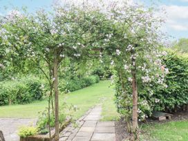 A garden with an archway covered in flowers at Whinstone Cottage Esk Valley near Grosmont