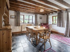 A dining room with a wooden table and chairs at Cove Cottage in Llangrannog