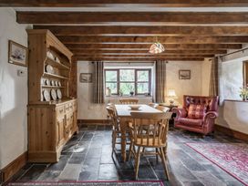 A dining room with wooden furniture at Cove Cottage in Llangrannog