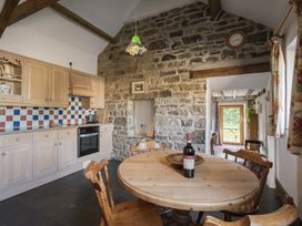 A kitchen with a round table and chairs at Cove Cottage in Llangrannog