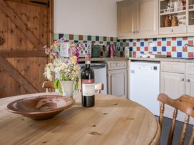 A kitchen with a table and chairs at Cove Cottage in Llangrannog