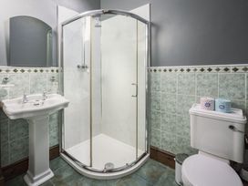 A bathroom with a shower, sink, and toilet at Cove Cottage Llangrannog
