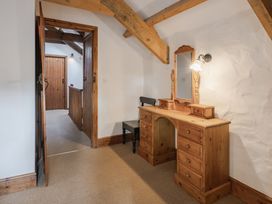 A hallway with a wooden vanity and mirror at Cove Cottage in Llangrannog