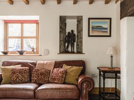A living room with a sofa and sculptures at Y Bwthyn in Llangrannog