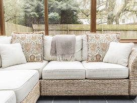 A couch with pillows and a blanket at Y Bwthyn in Llangrannog