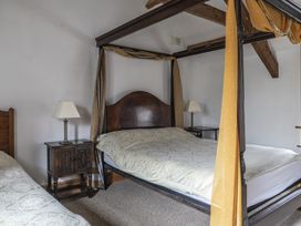 A bedroom with a four-poster bed and side table at Y Bwthyn in Llangrannog