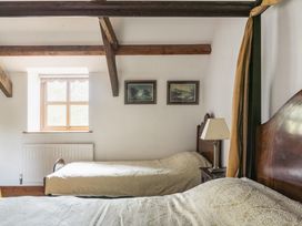 A bedroom with beds and paintings at Y Bwthyn Llangrannog