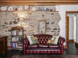 A living room with a sofa and bookshelf at Coach House in Llangrannog