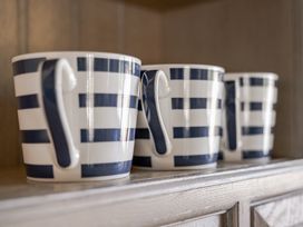 Three striped mugs on a shelf at Coach House in Llangrannog