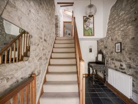 A hallway with stairs and a console table at Coach House in Llangrannog