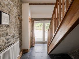 A hallway with a staircase and windows at Coach House in Llangrannog