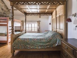 A bedroom with a four-poster bed and a bunk bed at Coach House in Llangrannog