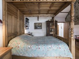 A bedroom with a wooden bed and wardrobe at Coach House Llangrannog