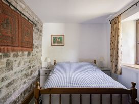 A bedroom with a bed and nightstand at Coach House in Llangrannog