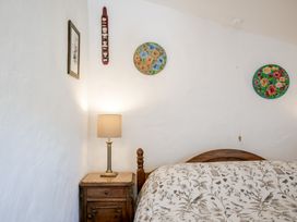 A bedroom with a bed and lamp at Coach House in Llangrannog