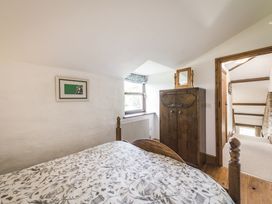 A bedroom with a bed and wardrobe at Coach House in Llangrannog