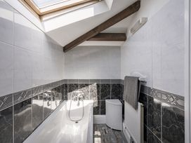A bathroom with a bathtub and towel rack at Coach House in Llangrannog