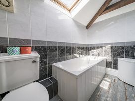 A bathroom with a bathtub and toilet at Coach House in Llangrannog