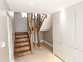 A hallway with a staircase and storage cabinet at Treliance in Truro