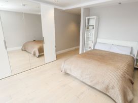 A bedroom with a bed and mirror at Treliance in Truro