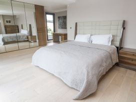 A bedroom with a bed and mirrored wardrobe at Treliance in Truro