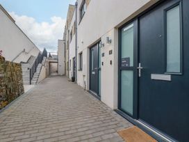A walkway with stairs on the left and doors on the right at Ebbtide in Newquay