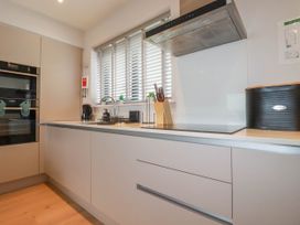 A kitchen with built in oven stovetop and countertop appliances at Ebbtide in Newquay