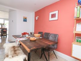 A dining area with a wooden table, chairs, a bench with a fur cover, and food on the table at Joymead in Malborough