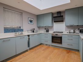 A modern kitchen with grey cabinets and appliances at The Well House Lyme Regis