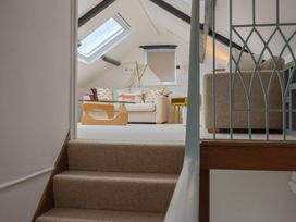A living room with a sofa and coffee table seen from the staircase at The Well House in Lyme Regis