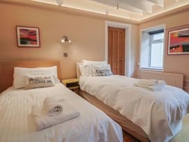 A bedroom with two beds and a window at The Well House in Lyme Regis