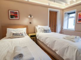 A bedroom with two single beds and a window at The Well House in Lyme Regis