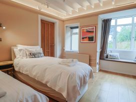 A bedroom with two beds and a window at The Well House in Lyme Regis
