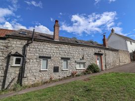 An outdoor view of a stone property with windows and a door at The Well House in Lyme Regis