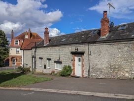 An exterior view of a stone building with a door and garden at The Well House in Lyme Regis