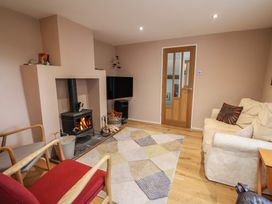 A living room with a wood stove and television at The Well House in Lyme Regis