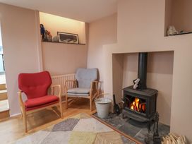 A living room with a fireplace and two armchairs at The Well House in Lyme Regis
