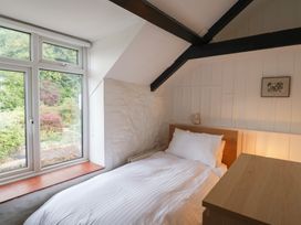 A bedroom with a bed and window at The Well House in Lyme Regis