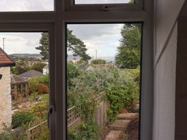 A view from a window showing a garden and trees at The Well House in Lyme Regis