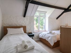 A bedroom with two beds and a window at The Well House in Lyme Regis