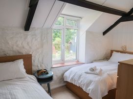 A bedroom with two beds and a window at The Well House in Lyme Regis