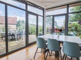 A dining room with a table and chairs overlooking the patio at The Well House in Lyme Regis