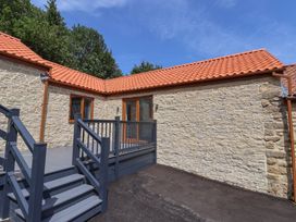 An outdoor area with a stone wall and wooden decking at Castle View in Scarborough