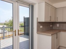 A kitchen with cabinets and double doors leading to a deck at Castle View in Scarborough