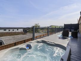 An outdoor area with a hot tub and chairs at Castle View in Scarborough