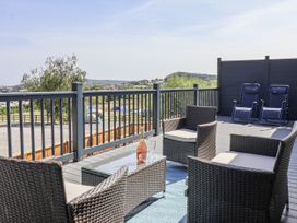 An outdoor patio with seating and a bottle of wine at Castle View in Scarborough