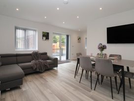 A living room with a sofa and dining area at Woodside in Scarborough
