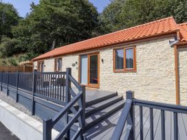 An outdoor area with a cottage and deck at Woodside in Scarborough