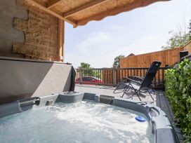 A hot tub with a deck and chairs at Woodside in Scarborough